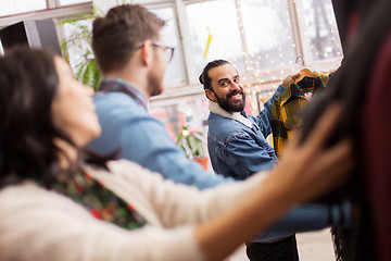 Image showing friends choosing clothes at vintage clothing store