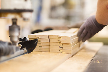 Image showing close up of carpenter hand with boards at factory