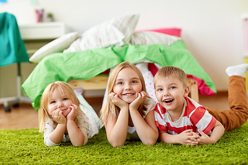 Image showing happy little kids lying on floor or carpet