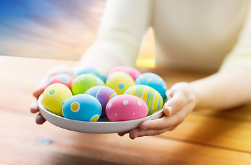 Image showing close up of woman hands with colored easter eggs