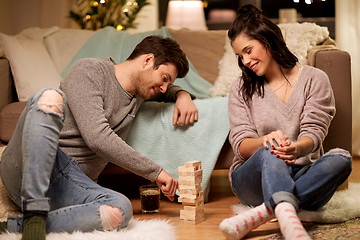 Image showing happy couple playing block-stacking game at home