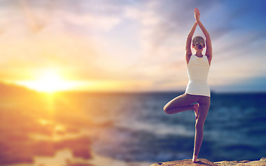 Image showing happy woman making yoga tree pose over sea