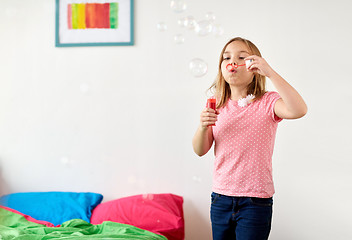 Image showing girl blowing soap bubbles at home