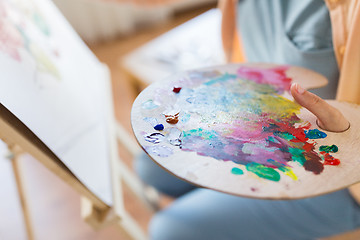 Image showing artist with paint palette painting at art studio