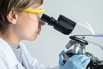 Image showing Scientist looking through a microscope