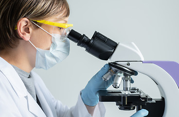 Image showing Scientist looking through a microscope