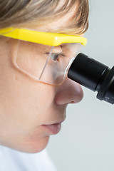 Image showing Scientist looking through a microscope