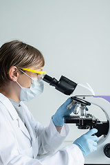 Image showing Scientist looking through a microscope