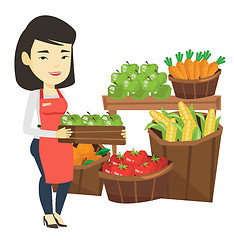 Image showing Supermarket worker with box full of apples.