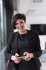 Image showing Elegant Woman Using Mobile Phone by window in office building