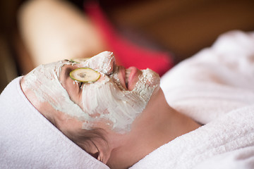 Image showing woman is getting facial clay mask at spa