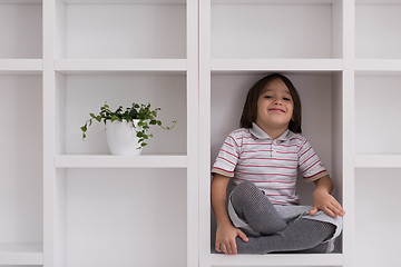 Image showing young boy posing on a shelf