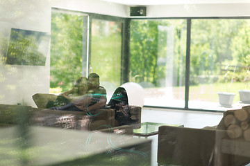 Image showing couple relaxing at  home with tablet and laptop computers