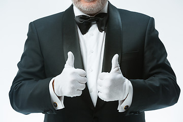 Image showing Senior waiter in white gloves