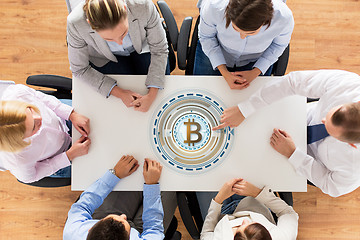 Image showing business team at table with bitcoin icon