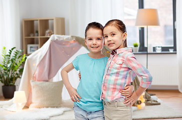 Image showing happy smiling little girls hugging at home