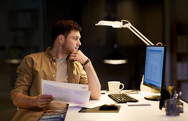 Image showing businessman with papers working at night office