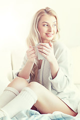 Image showing happy woman with cup of coffee in bed at home