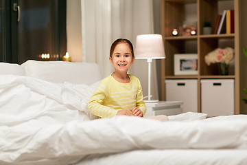 Image showing happy little girl in bed at home at night