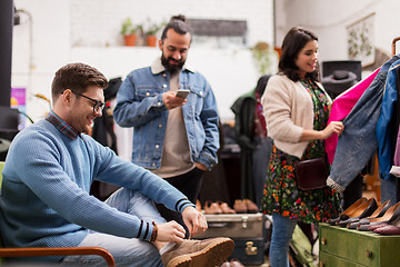 Image showing friends choosing clothes at vintage clothing store