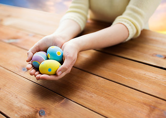 Image showing close up of woman hands with colored easter eggs