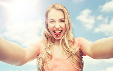 Image showing happy smiling young woman taking selfie