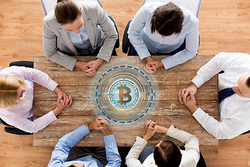 Image showing business team at table with bitcoin icon