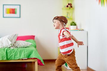 Image showing happy little boy in pilot hat playing at home