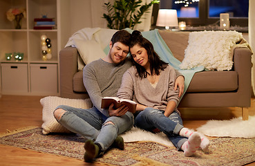 Image showing happy couple reading book at home