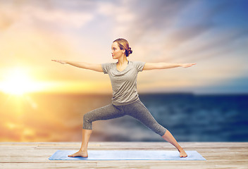 Image showing woman making yoga warrior pose on mat