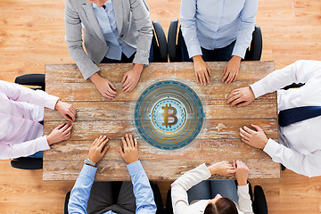 Image showing business team at table with bitcoin icon