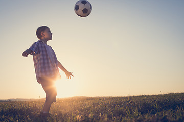 Image showing Young little boy playing in the field  with soccer ball.