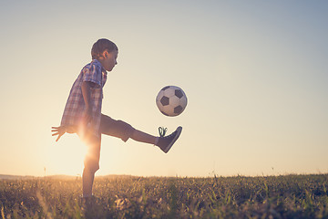 Image showing Young little boy playing in the field  with soccer ball.