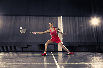 Image showing Young woman playing badminton at gym