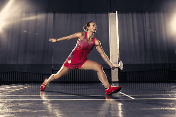 Image showing Young woman playing badminton at gym