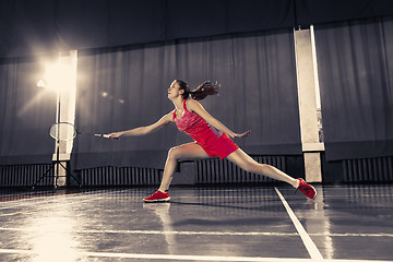 Image showing Young woman playing badminton at gym