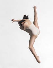 Image showing Young beautiful dancer in beige dress dancing on gray background