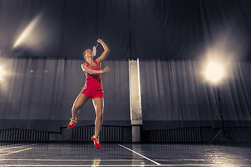 Image showing Young woman playing badminton at gym