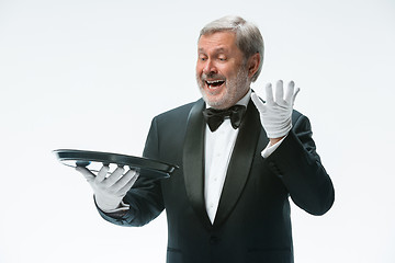 Image showing Senior waiter holding tray