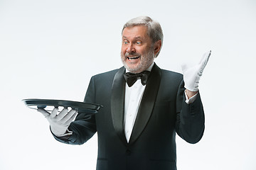 Image showing Senior waiter holding tray