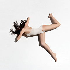 Image showing Young beautiful dancer in beige dress dancing on gray background