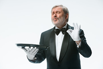 Image showing Senior waiter holding tray