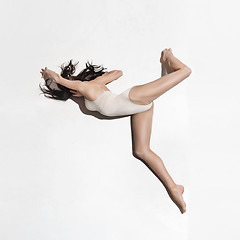 Image showing Young beautiful dancer in beige dress dancing on gray background