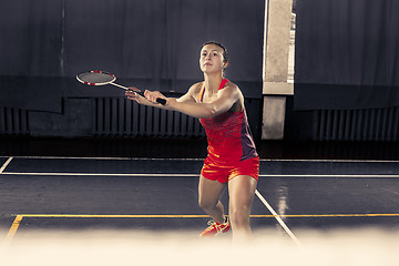 Image showing Young woman playing badminton at gym