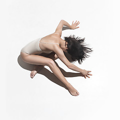 Image showing Young beautiful dancer in beige dress dancing on gray background