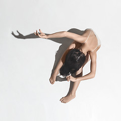 Image showing Young beautiful dancer in beige dress dancing on gray background