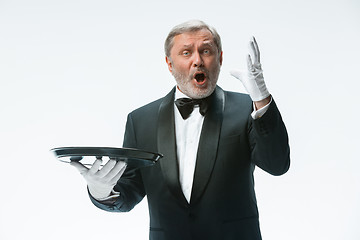 Image showing Senior waiter holding tray