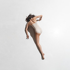 Image showing Young beautiful dancer in beige dress dancing on gray background
