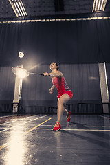 Image showing Young woman playing badminton at gym