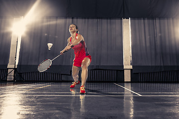 Image showing Young woman playing badminton at gym